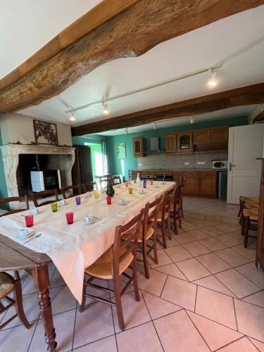 une grande salle à manger avec une longue table et des chaises dans l'établissement Havre de paix en bourgogne, à Saint-Clément-sur-Guye