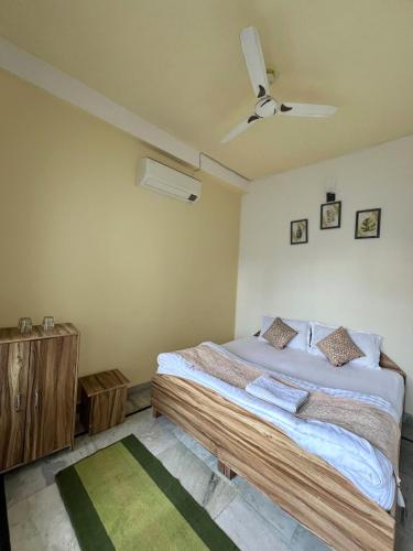 a bedroom with a bed and a ceiling fan at Gangesh Hotel in Rishīkesh