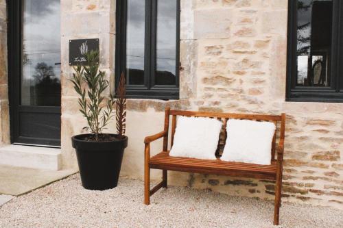 a bench with two pillows sitting in front of a building at La Bergerie à Palleau, Les Blés Dorés et Les Graines de Lin à Corgengoux, proches de Beaune et de ses villages viticoles in Palleau
