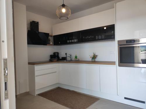 a kitchen with white cabinets and a microwave at Penthouse apartment in Gornji Karin near the beach in Anić