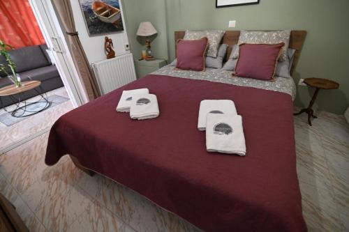 ein Schlafzimmer mit einem Bett mit zwei Handtüchern darauf in der Unterkunft Augoustinos - Sea Side Luxury Apartments in Artemida