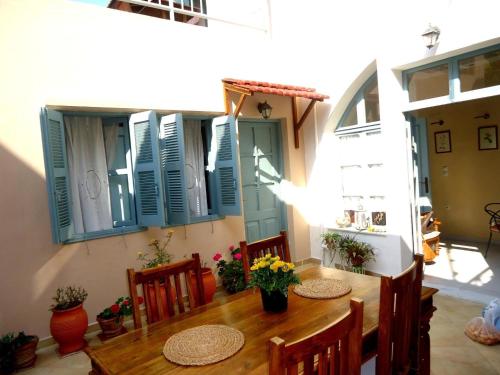 une salle à manger avec une table, des chaises et des volets bleus dans l'établissement Casa Antica, à Rhodes
