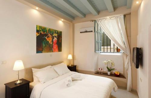 - une chambre avec un lit blanc et une fenêtre dans l'établissement Casa Antica, à Rhodes