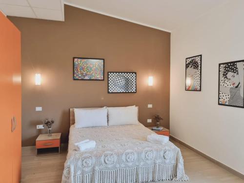 - une chambre avec un lit avec deux tables et deux photos sur le mur dans l'établissement Agri B&B Terre Joniche, à Isola di Capo Rizzuto