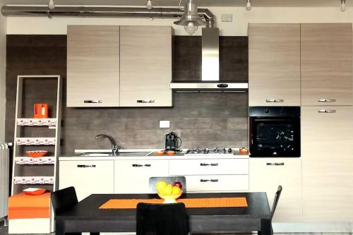 a kitchen with white cabinets and a table and a sink at Casa Venere in Oliveto Citra