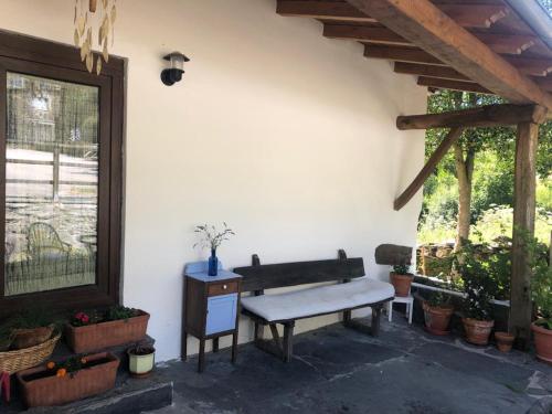 a bench sitting next to a wall with potted plants at CASA DA LOAIRA in Quiroga