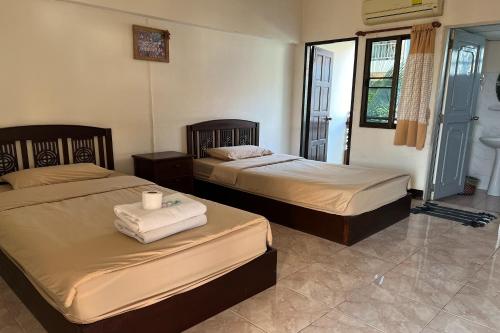 a bedroom with two beds with towels on them at Sripoom House 1 in Chiang Mai