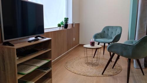 un salon avec deux chaises et une télévision dans l'établissement Cantinho dos Remédios, à Lajes