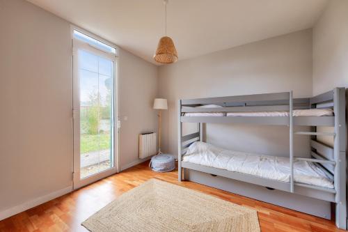 une chambre avec deux lits superposés et une fenêtre dans l'établissement À 300m de la plage, maison pour 7 avec piscine, à Lanton