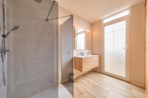 une salle de bain avec une douche en verre et un lavabo dans l'établissement À 300m de la plage, maison pour 7 avec piscine, à Lanton