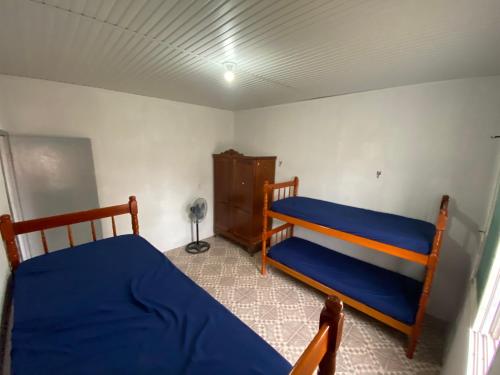 a bedroom with two bunk beds in a room at Casa com 2 quartos grandes a 150m da praia in Rio Grande