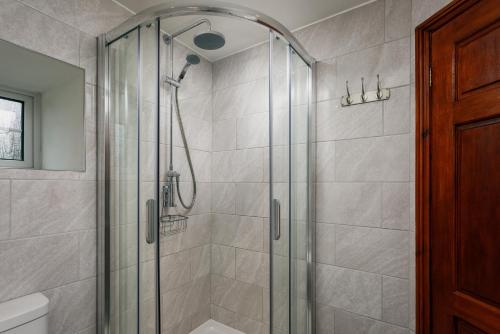 een badkamer met een douche en een glazen deur bij Lanjew Park in Bodmin