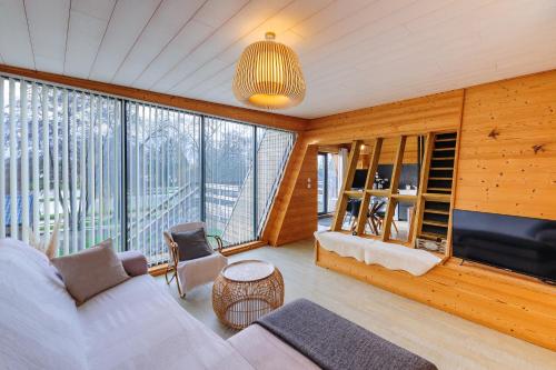 un salon avec un canapé et une grande fenêtre dans l'établissement Cottage 2 chambres - Chalet climatisé pour 4, à Malzy