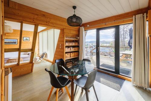une salle à manger avec une table et des chaises en verre dans l'établissement Cottage 2 chambres - Chalet climatisé pour 4, à Malzy