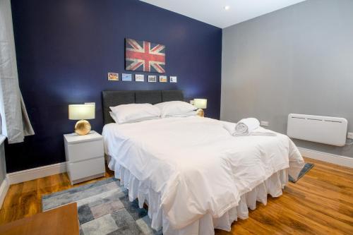 ein Schlafzimmer mit einem großen Bett mit blauer Wand in der Unterkunft Pass the Keys Lincoln room at Tavmar Apartments in Lincoln