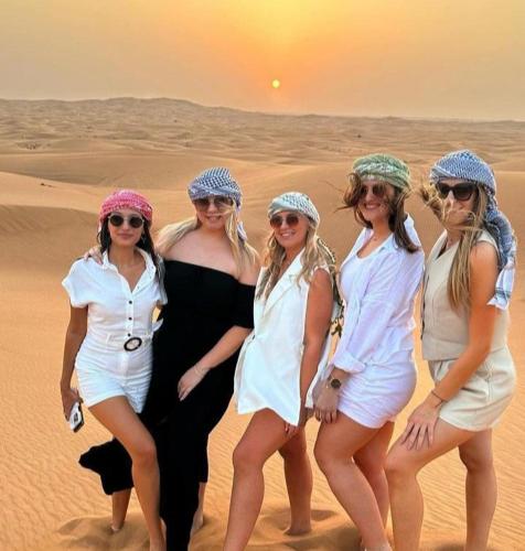 a group of women standing in the desert at Merzouga Luxurious Camp in Merzouga