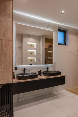 a bathroom with two sinks and a large mirror at Villa 4A Visoko in Visoko