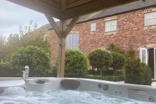 a hot tub in front of a brick building at The Stable's Barn in Bigby in Barnetby le Wold