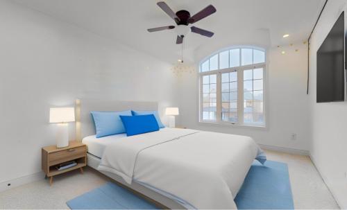 a white bedroom with a bed and a ceiling fan at Luxurious Stay in the Heart of Community in Brampton