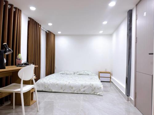 a bedroom with a bed and a desk and a chair at Alley Homestay Sai Gon in Ho Chi Minh City