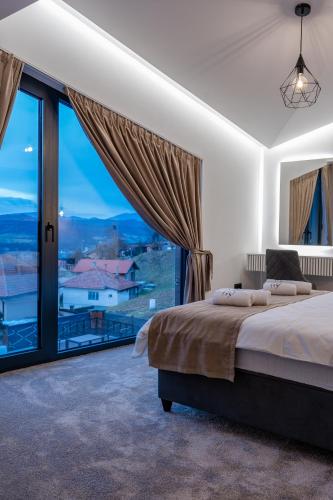 a bedroom with a large bed and a large window at Villa 4A Visoko in Visoko