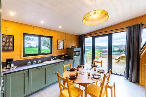 une cuisine avec une table et des chaises dans une pièce dans l'établissement Cottage 3 chambres - Chaleureux chalet pour 6, à Malzy
