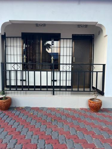 a front door of a building with two potted plants at Kilimanjaro Trekcity Hostel in Moshi