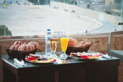 a table with two glasses of beer and food at Egypt Pyramids Inn in Cairo