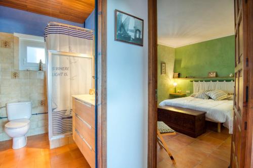 een slaapkamer met een bed en een badkamer bij Mas Tomasi 215 in Pals