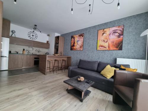 uma sala de estar com um sofá e uma cozinha em Q Apart Gold-3 Pokoje Manufaktura Garaż Netflix Klimatyzacja, FV, em Łódź