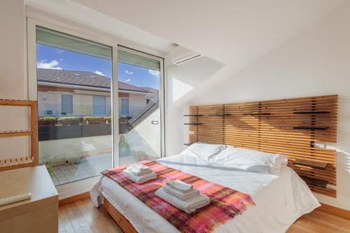 um quarto com uma cama e uma grande janela em Seréla Suite em Bérgamo