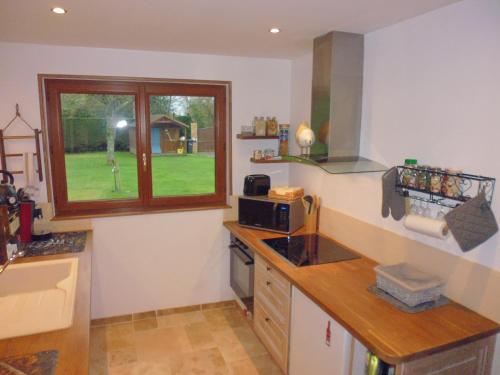 a kitchen with a counter top and a window at Augettes Bergerie in Saint-Hymer