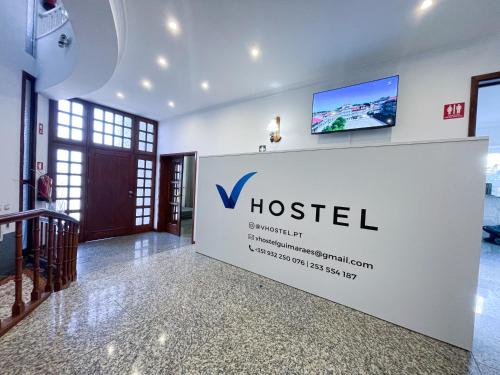 um sinal para um hotel numa parede no átrio em VHostel em Guimarães