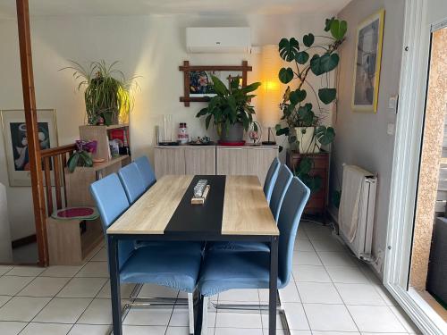 une salle à manger avec une table et des chaises bleues dans l'établissement Maison au soleil, à Banyuls-sur-Mer