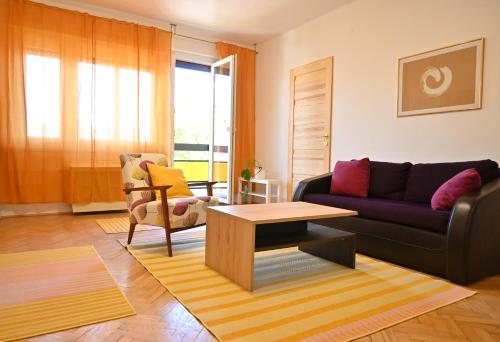 ein Wohnzimmer mit einem Sofa und einem Tisch in der Unterkunft Rose Hill 4 in Budapest