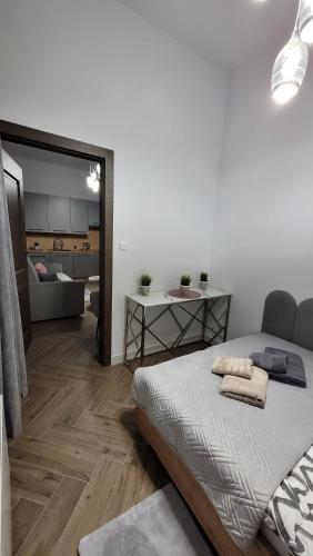 a bedroom with a bed and a living room at APARTAMENT JARACZA 28/10 in Słupsk