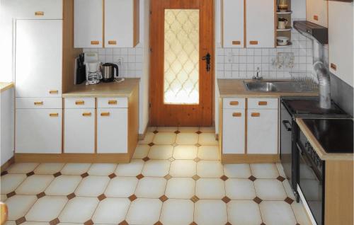 a kitchen with white cabinets and a tiled floor at Ferienhaus In Untertilliach in Untertilliach