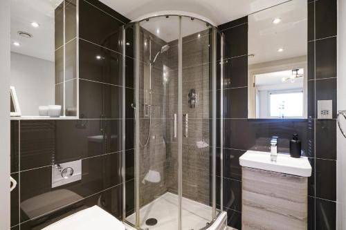 a bathroom with a shower and a toilet and a sink at Luxury Apartment With Stunning Views on 10th floor in Edgware