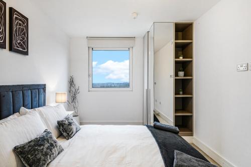 ein weißes Schlafzimmer mit einem Bett und einem Fenster in der Unterkunft Luxury Apartment With Stunning Views on 10th floor in Edgware