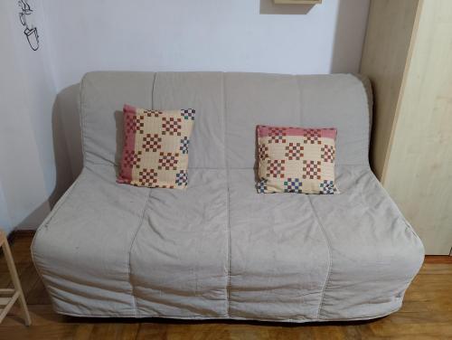 a gray couch with two pillows on it at Guardavalle in Chiomonte