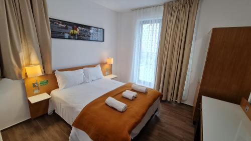 - une chambre avec un grand lit et 2 serviettes dans l'établissement Jafar Resort 2, à Timişoara
