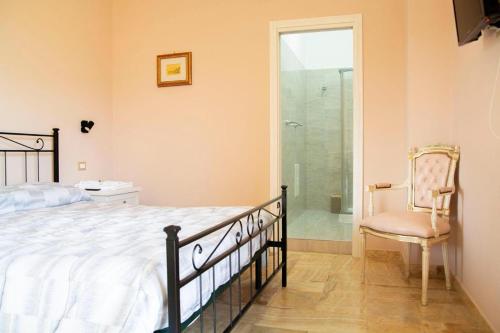 um quarto com uma cama, uma cadeira e um chuveiro em Colazione da Tiffany - Villa Bei Ricordi - B&B - Spa privata em Santa Lucia di Serino
