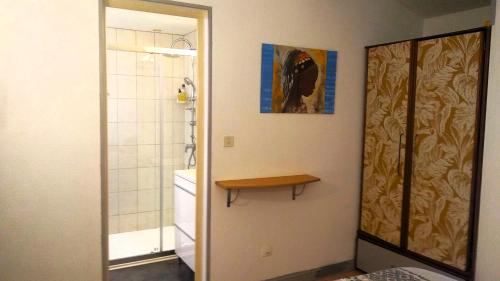 a bathroom with a shower and a table on the wall at Chambre Indépendante Piscine, Parc, Cuisine... in Brézilhac