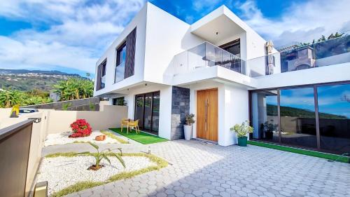 a white villa with a view of the mountains at Allure Alannas Villa by LovelyStay in Funchal