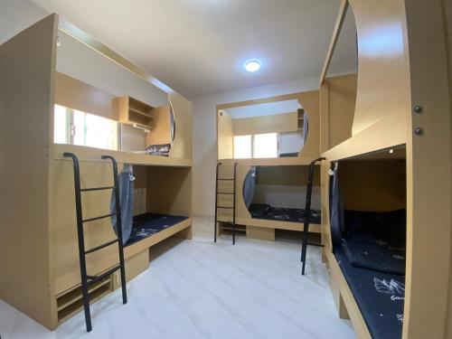 a room with two bunk beds and a room with mirrors at Loong Hostel in Riyadh