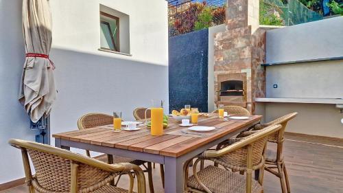 a wooden table and chairs on a patio at Allure Alannas Villa by LovelyStay in Funchal