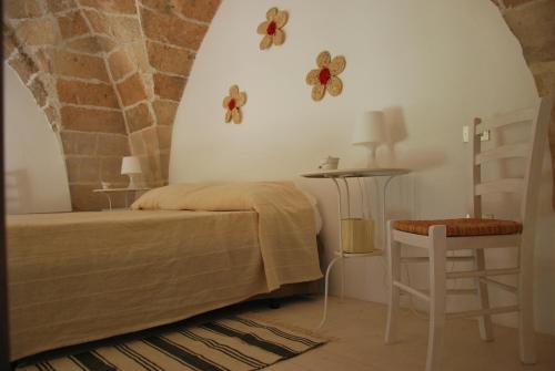 - une chambre avec un lit, une table et une chaise dans l'établissement Masseria Don Vito, à Merine