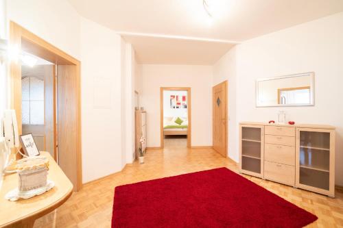sala de estar con alfombra roja en el suelo en Ferienwohnung Matzelsdorferhof, en Millstatt