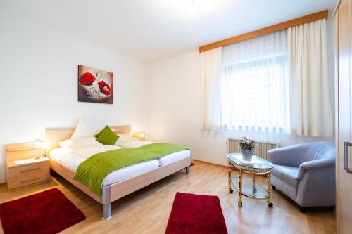 1 dormitorio con 1 cama, 1 sofá y 1 silla en Ferienwohnung Matzelsdorferhof, en Millstatt
