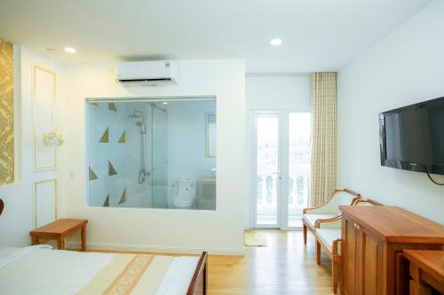 1 dormitorio con espejo grande y TV en khách sạn Quốc Tế en Cà Mau